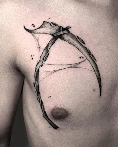 Tatuaje de una guadaña con detalles en forma de telaraña en el pecho. Tinta negra, diseño abstracto.