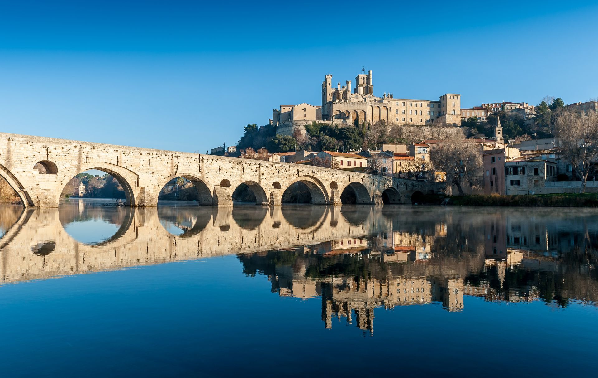 Vue d'un pont de pierre et d'un cours d'eau à proximité de la ville de Béziers