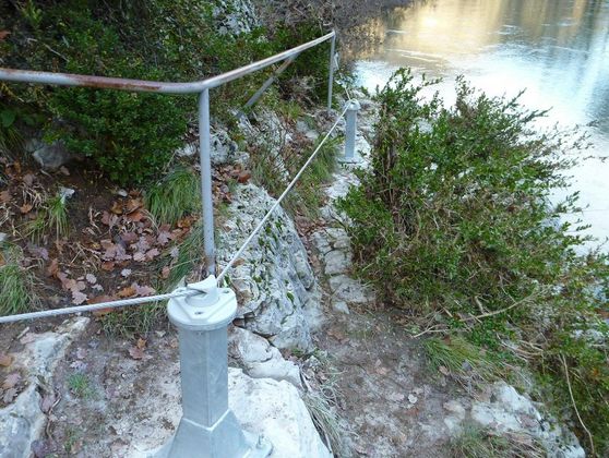 Ligne de vie et rambarde de sécurité en milieu naturel, près d'un point d'eau
