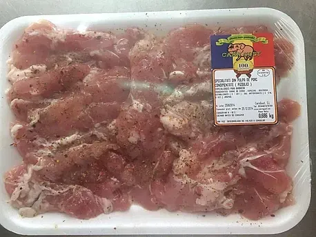 Una bandeja de carne con una etiqueta está sobre una mesa.