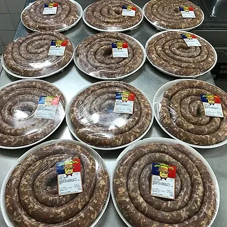 Un montón de salchichas están colocadas en platos sobre una mesa.