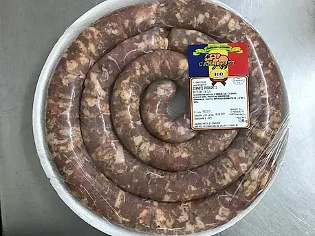 Un plato de salchichas con una etiqueta está sobre una mesa.