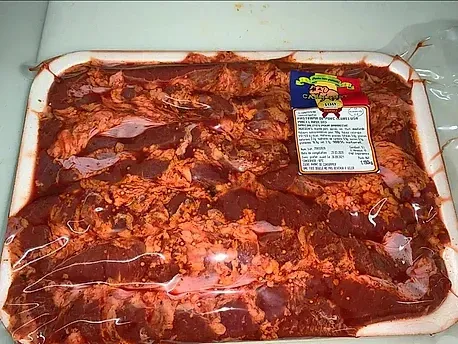 Una bandeja de carne con una etiqueta está sobre una mesa.