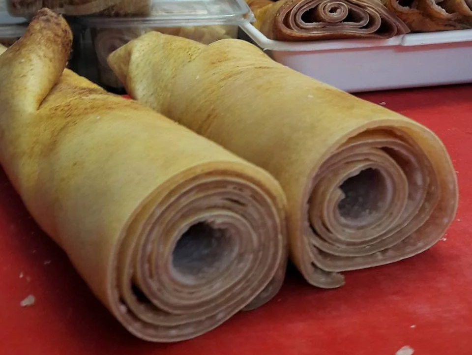 Dos rollos de comida están sobre una mesa roja.