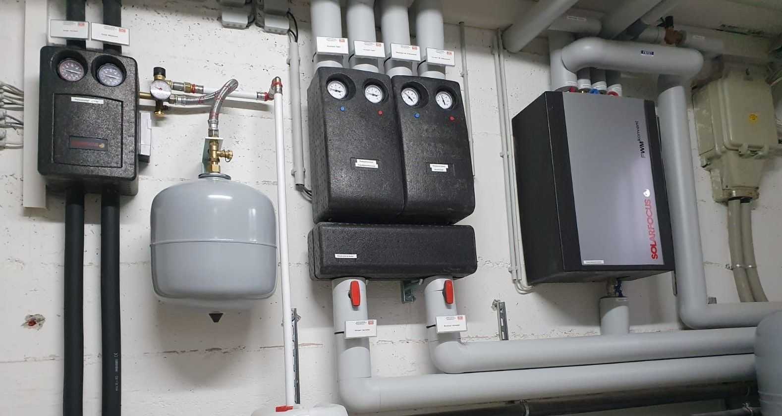 Ein Raum mit vielen Rohren und Kästen an der Wand.