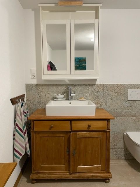 Ein Badezimmer mit einem Holzschrank und einem Waschbecken