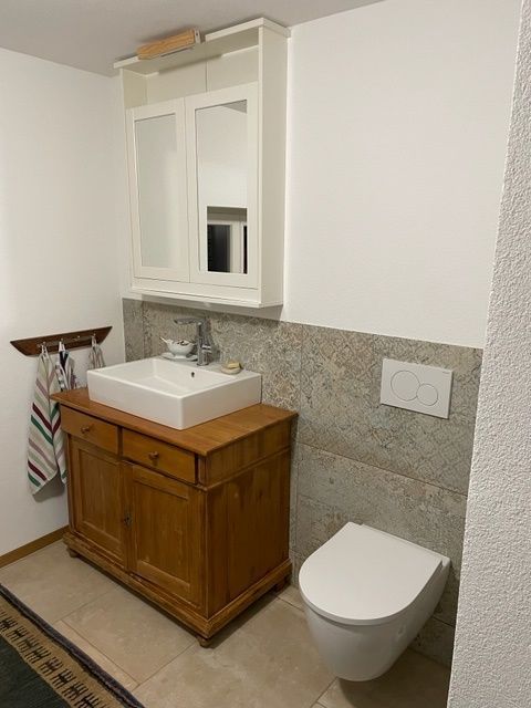 Ein Badezimmer mit Toilette, Waschbecken und Spiegel