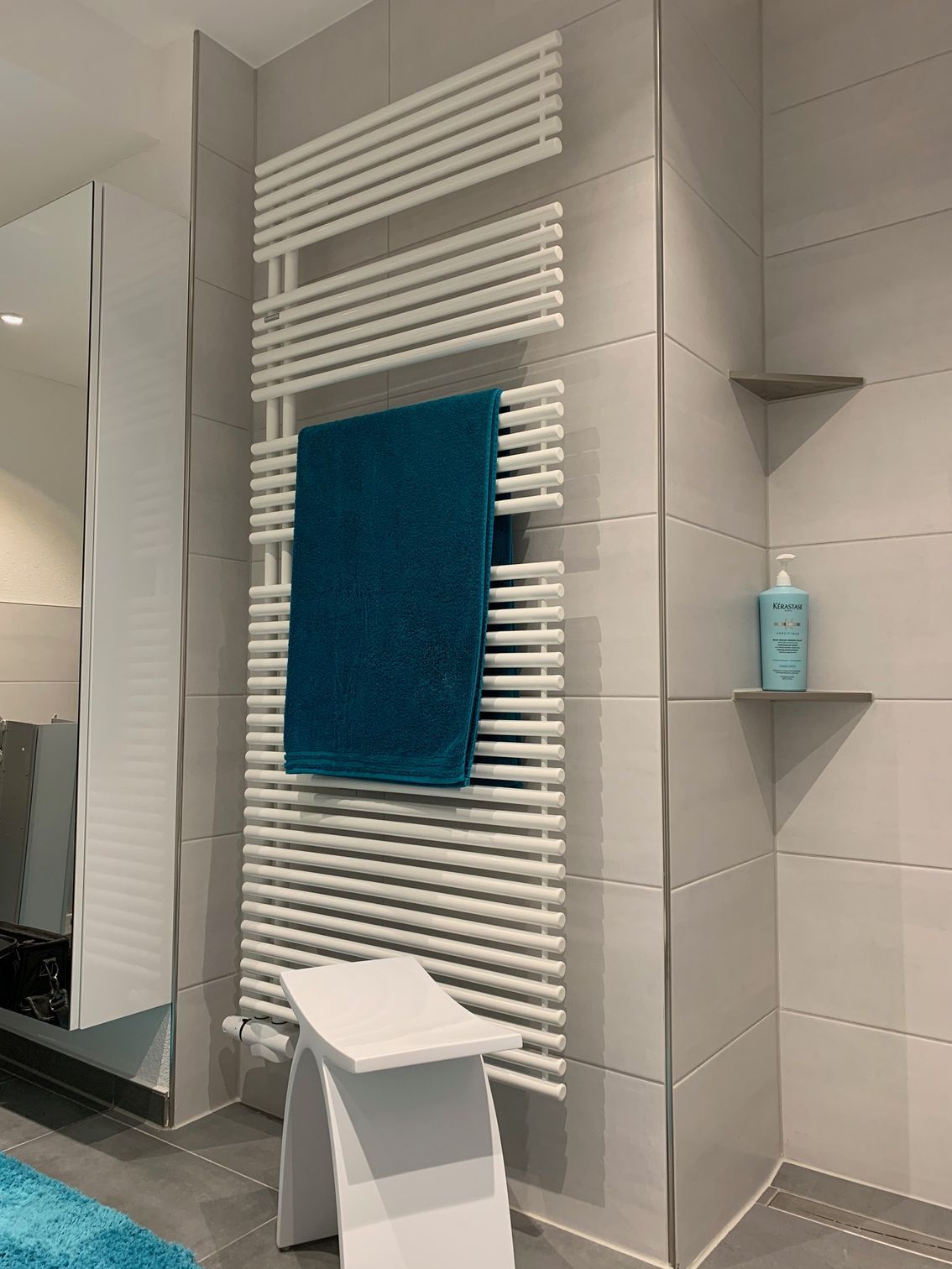 Ein blaues Handtuch hängt an einem weißen Handtuchhalter in einem Badezimmer