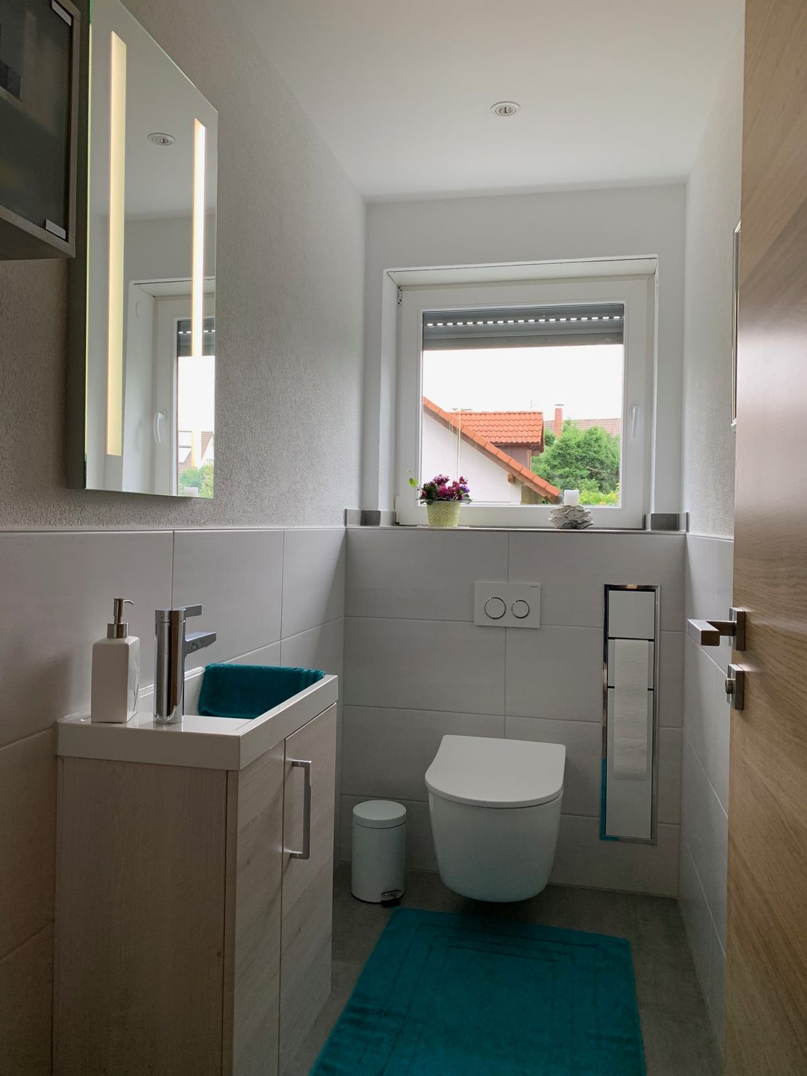 Ein Badezimmer mit Toilette, Waschbecken und Fenster