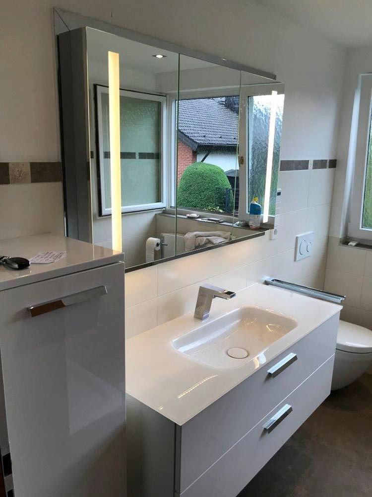 Ein Badezimmer mit Waschbecken, Toilette und Spiegel.