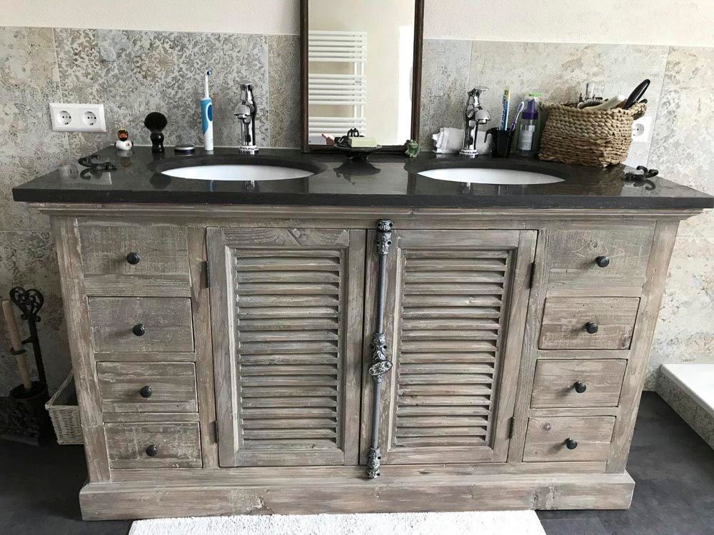 Ein Badezimmerschrank mit zwei Waschbecken und einem Spiegel.