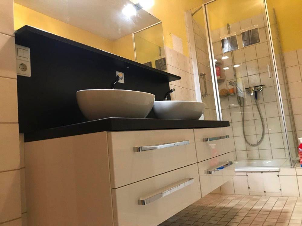 Ein Badezimmer mit zwei Waschbecken und einer Duschkabine.