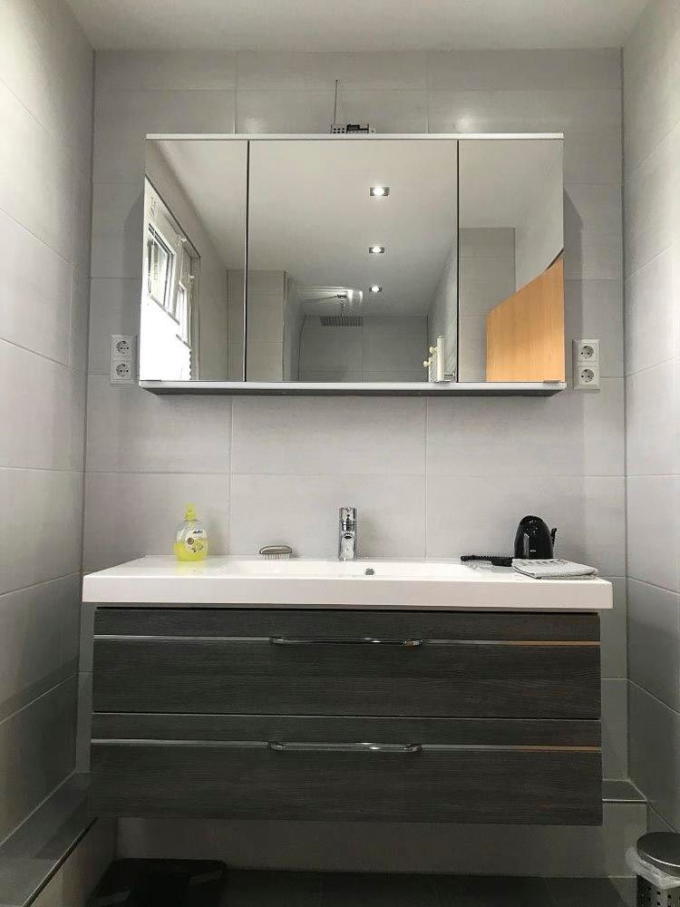 Ein Badezimmer mit einem Waschbecken und einem Spiegel darüber.