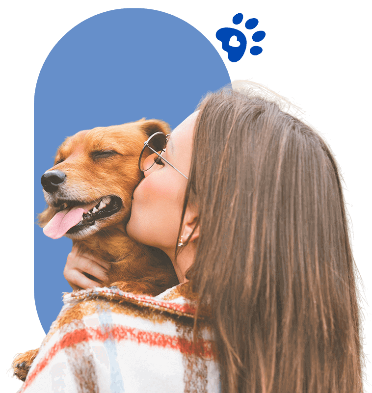 Una mujer está besando a un perro marrón en la mejilla.