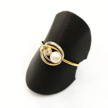 Un anillo de oro y plata con una perla y un diamante.