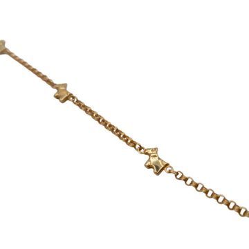 Una pulsera de oro con estrellas sobre un fondo blanco.