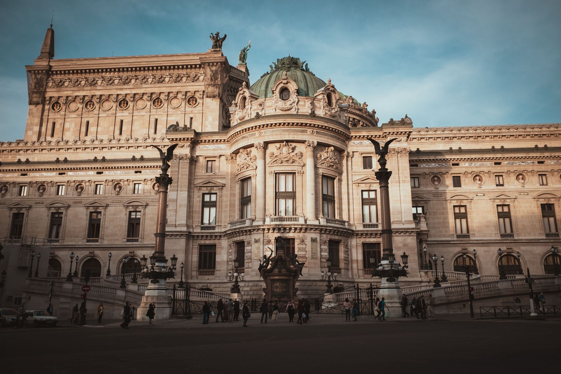 Ornate historic palace facade with central dome and statues under a cloudy sky