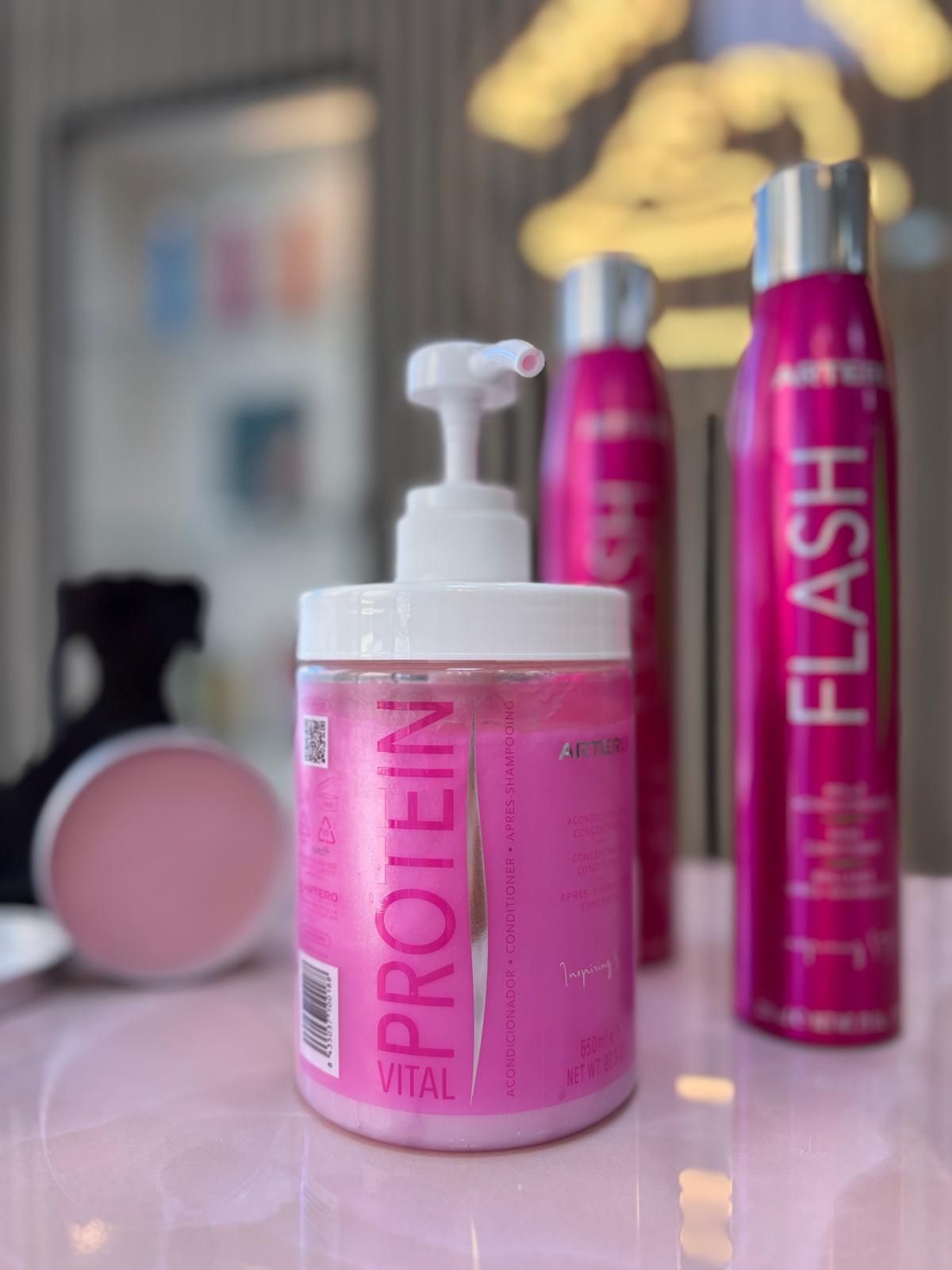 Una botella rosa con la palabra proteína escrita en ella.