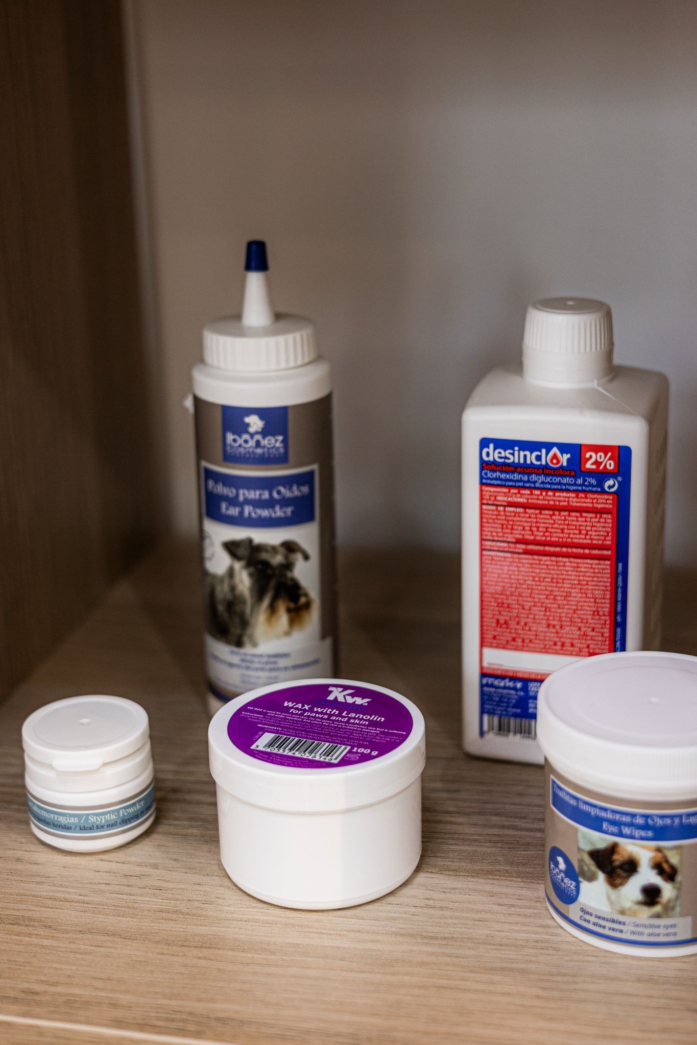 Un estante lleno de botellas y frascos de suministros para perros.