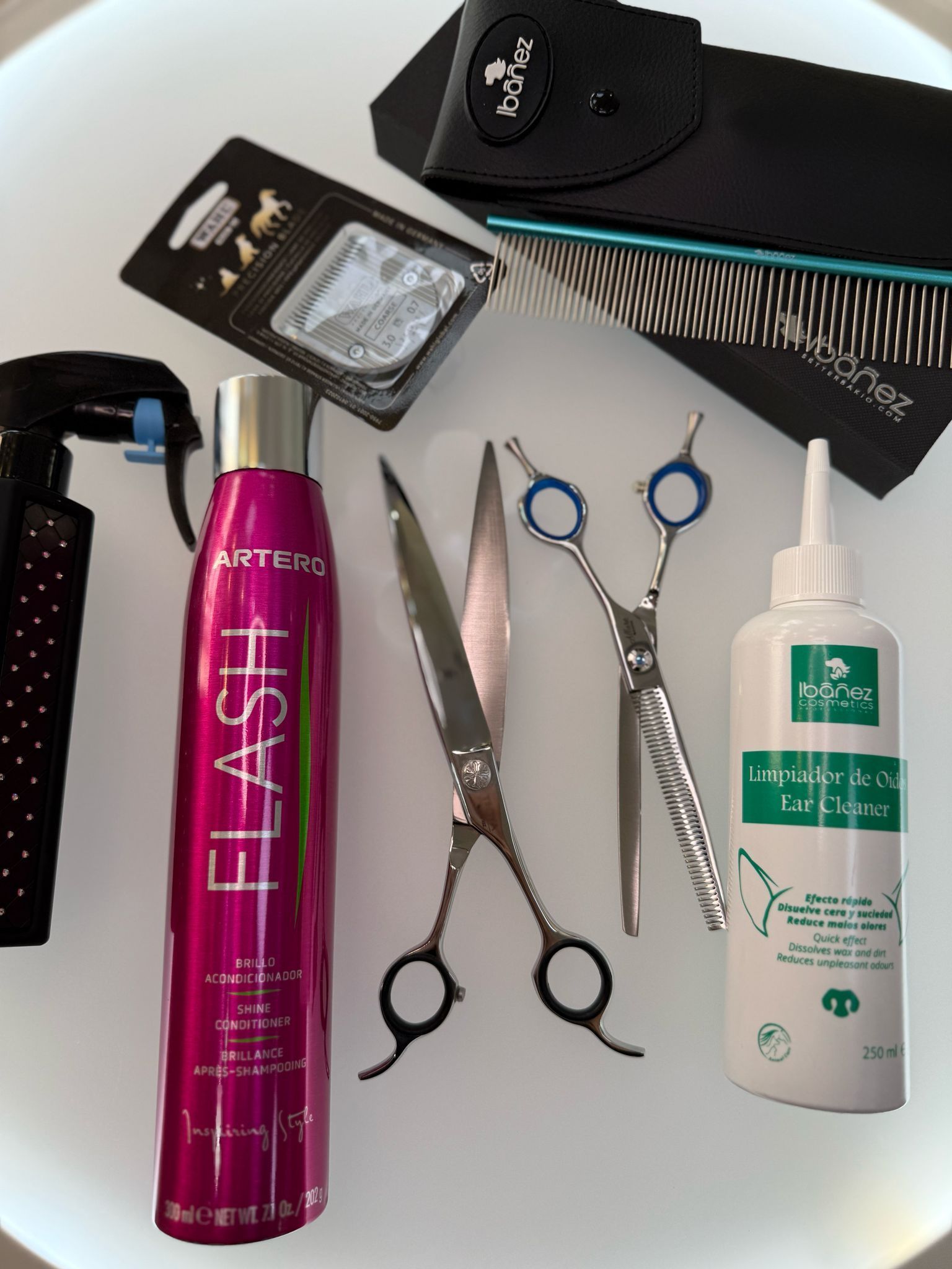 Una botella de spray flash se encuentra junto a un par de tijeras.