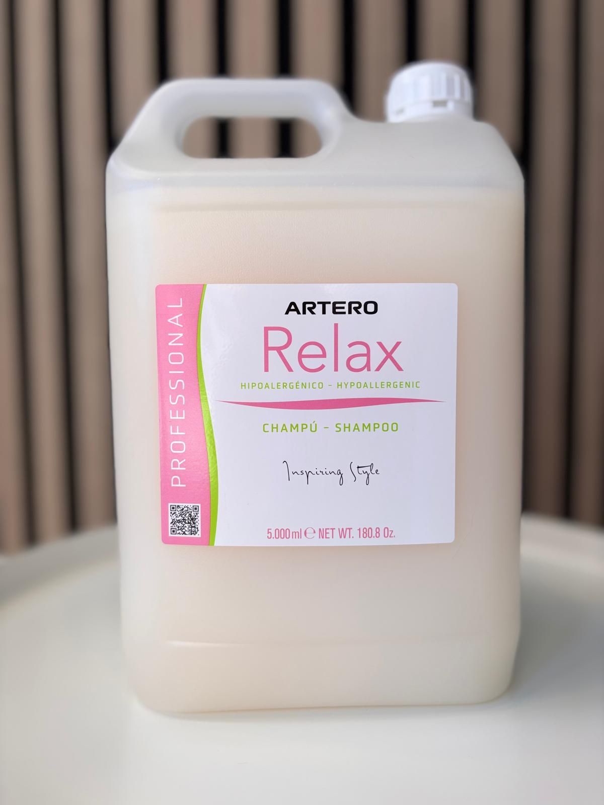 Una botella de champú Artero Relax está sobre una mesa.