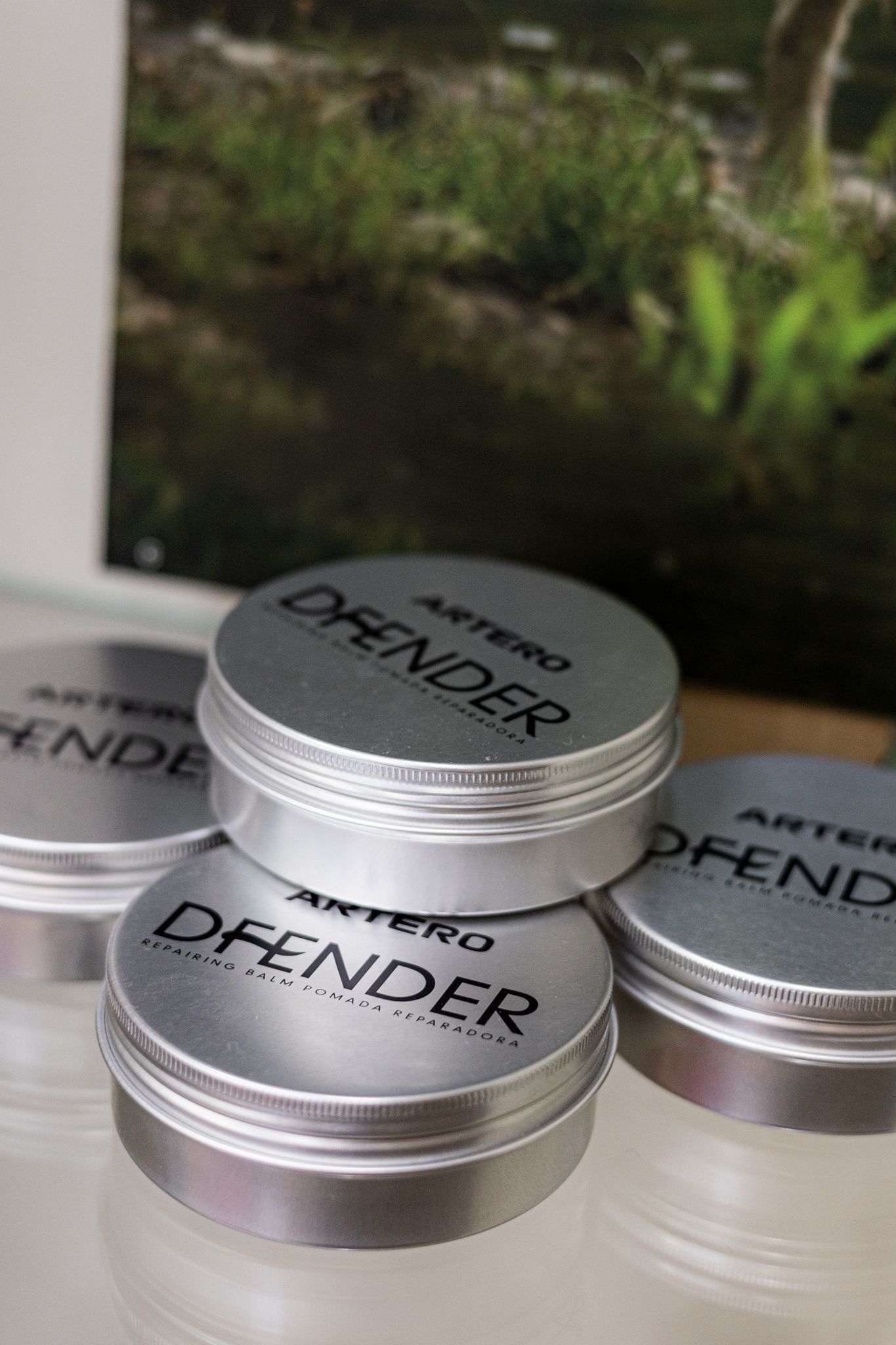 Tres latas de Defender están apiladas una encima de otra.