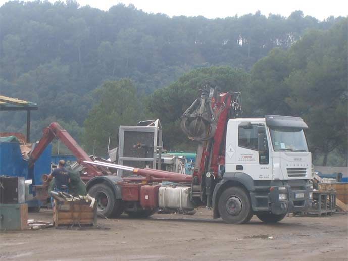 Un camión rojo y blanco con una grúa acoplada.
