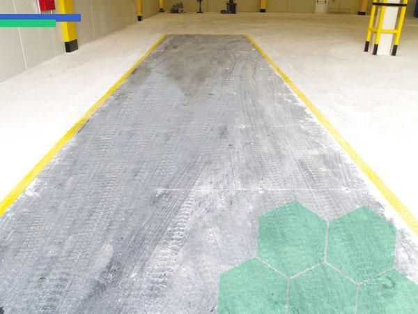 Un piso de concreto con una línea amarilla sobre él.