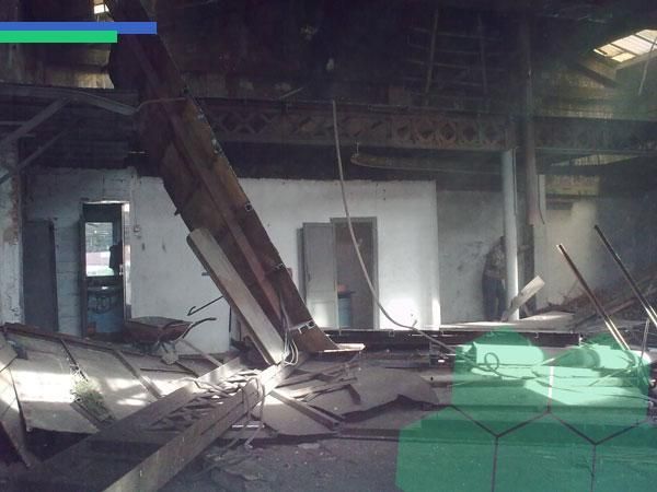 Un edificio que está siendo demolido con una caja verde en el medio.
