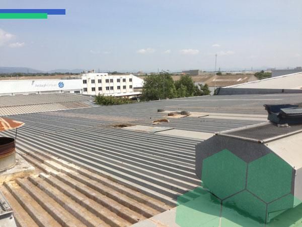 Un techo de un edificio con un edificio blanco al fondo.