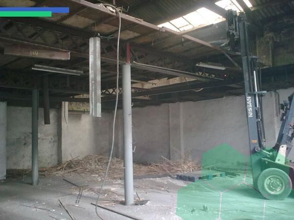 Una carretilla elevadora está estacionada en un almacén vacío.