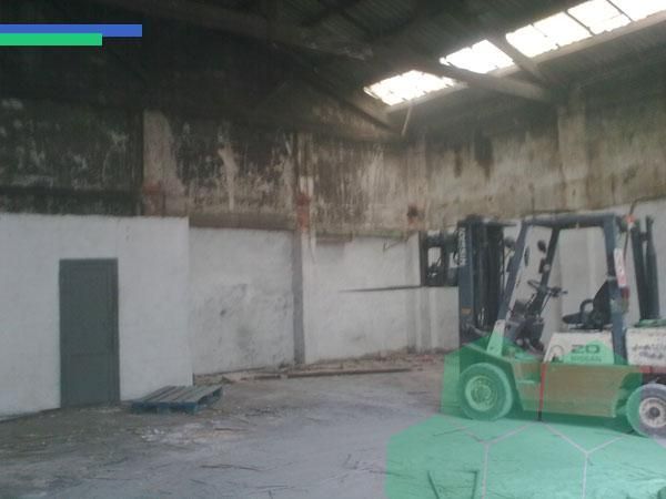 Una carretilla elevadora está estacionada en un almacén vacío