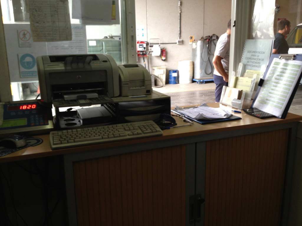 Un escritorio con una impresora y un teclado encima.