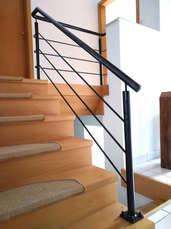 Eine Reihe von Holztreppen mit einem schwarzen Geländer