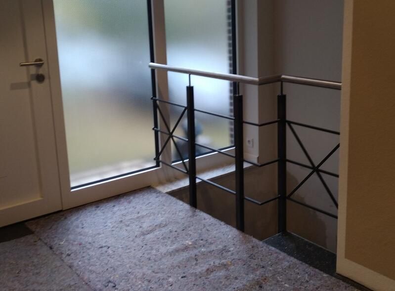 Eine Treppe mit Geländer und Glastür