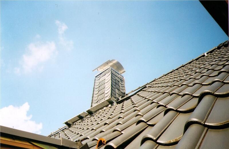 Blick nach oben auf einen Schornstein auf einem Dach