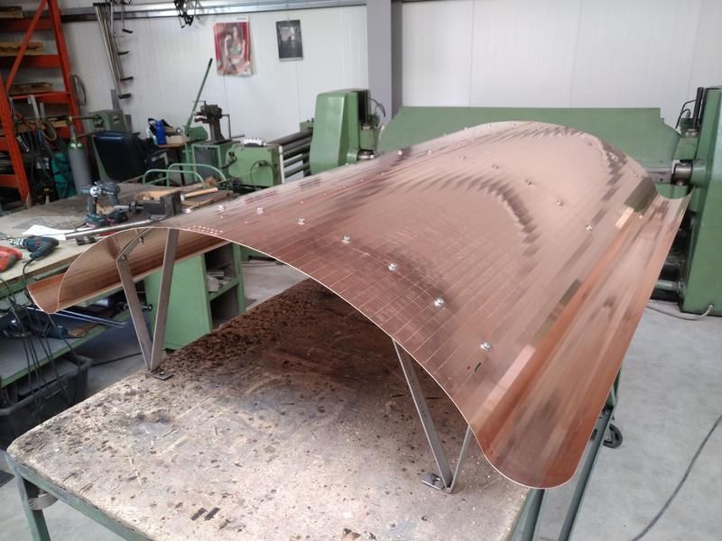 Ein Schornsteinschutz liegt auf einem Tisch in einer Werkstatt