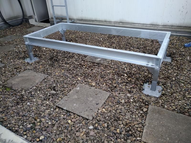 Auf einem Kieshaufen steht ein Metallrahmen.