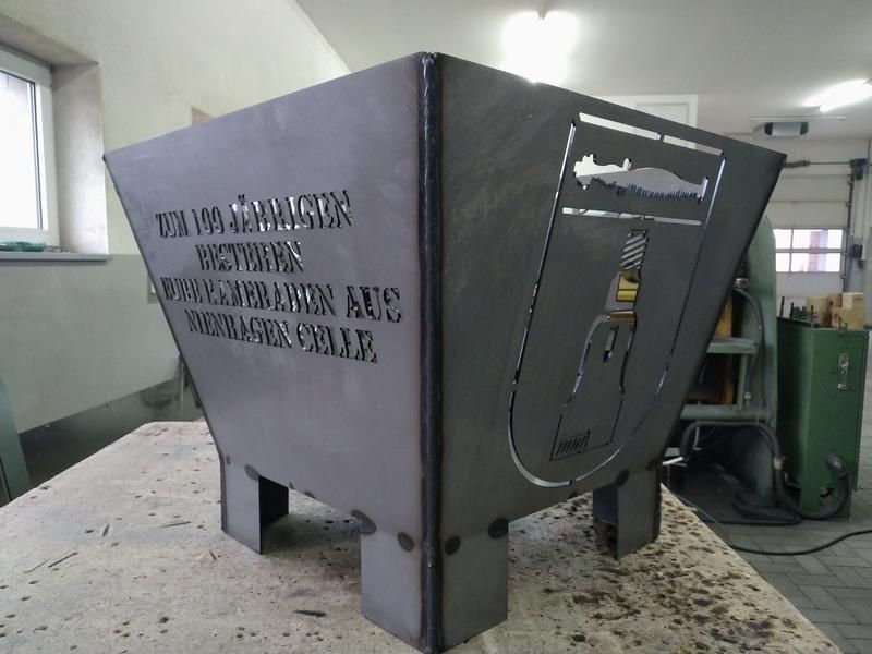 Ein Metallbehälter mit einem Fisch darauf steht auf einem Tisch