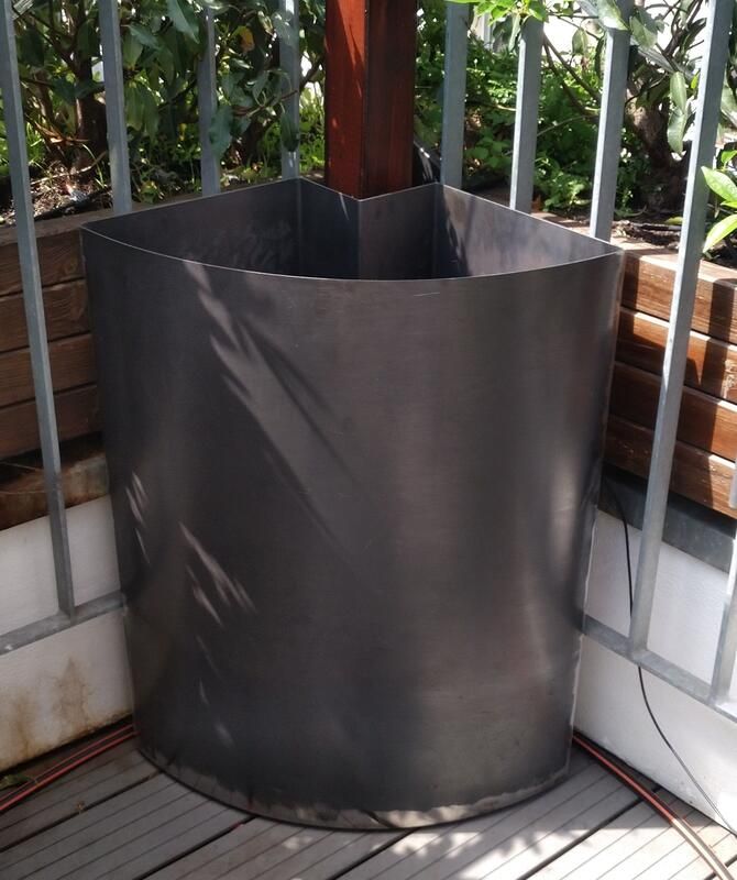 Ein großer Metallzylinder steht auf einem Holzdeck