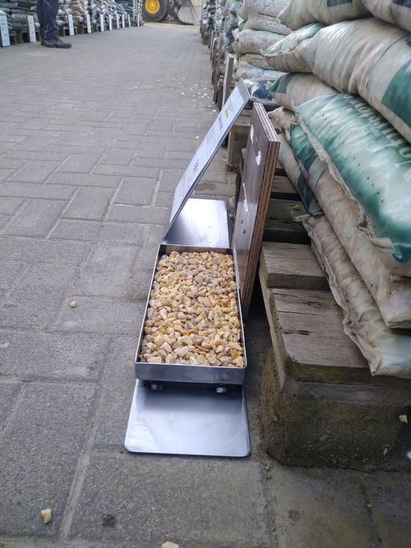 Auf dem Bürgersteig steht eine Kiste mit Lebensmitteln neben einem Stapel Tüten.