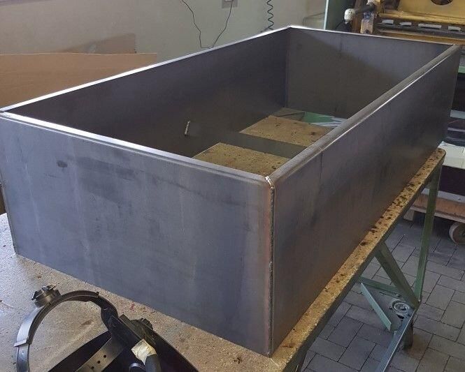 Eine große Metallkiste steht auf einem Holztisch