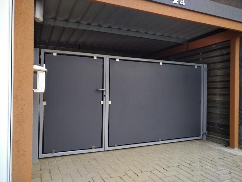 Eine Garage mit einem grauen Tor und einem Briefkasten