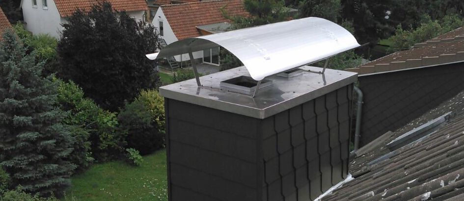 Ein Schornsteinschutz auf einem Gebäude mit einem Vordach darüber