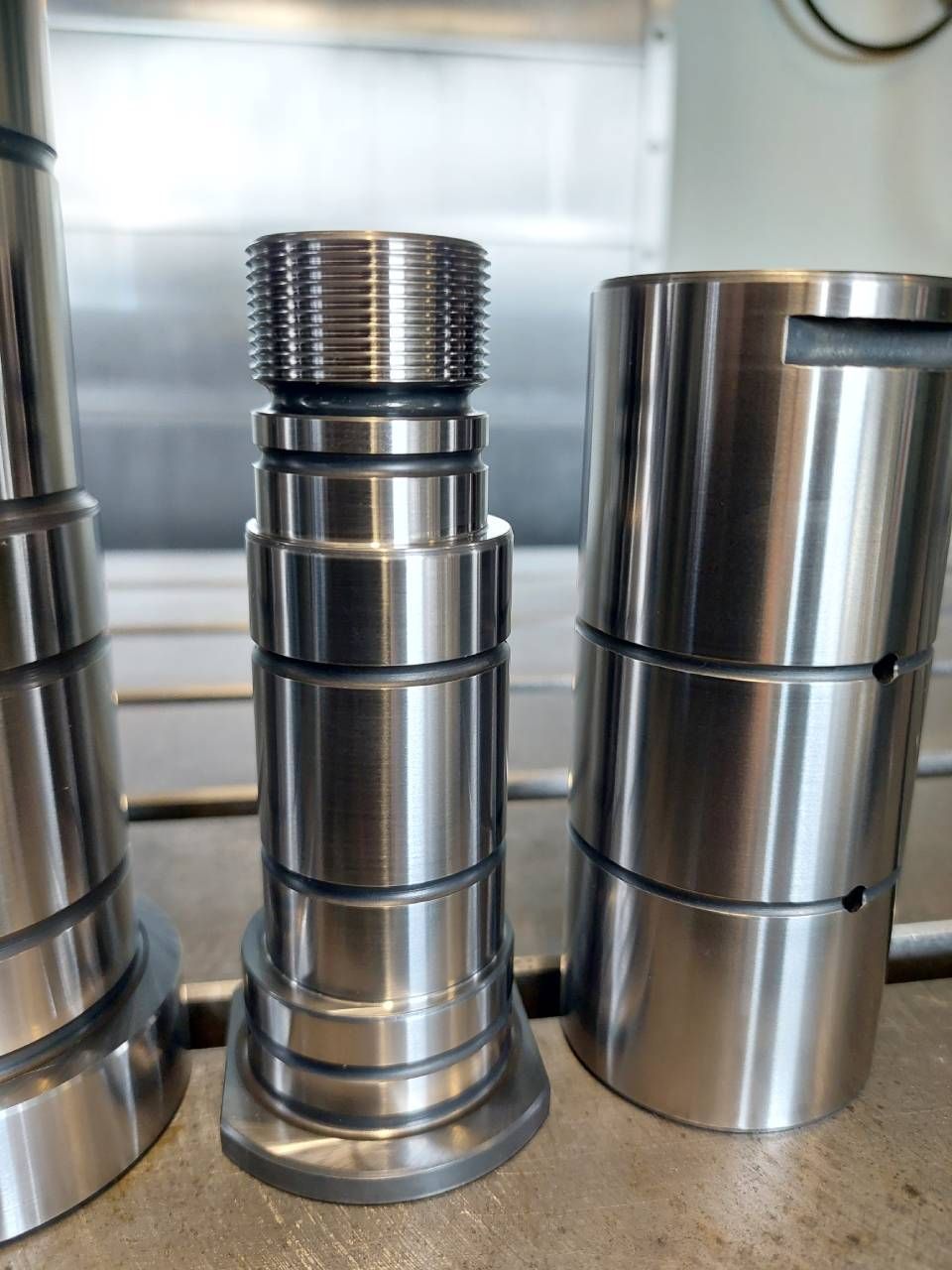 Auf einer Oberfläche befinden sich zwei rechteckige Metallplatten mit Rillen, Bohrungen und anderen Metallobjekten.