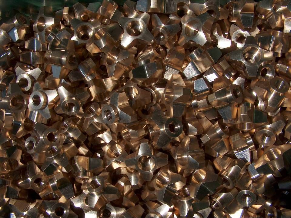 Ein Haufen kleiner, messingfarbener Metallarmaturen, möglicherweise für Sanitär- oder Industriezwecke.