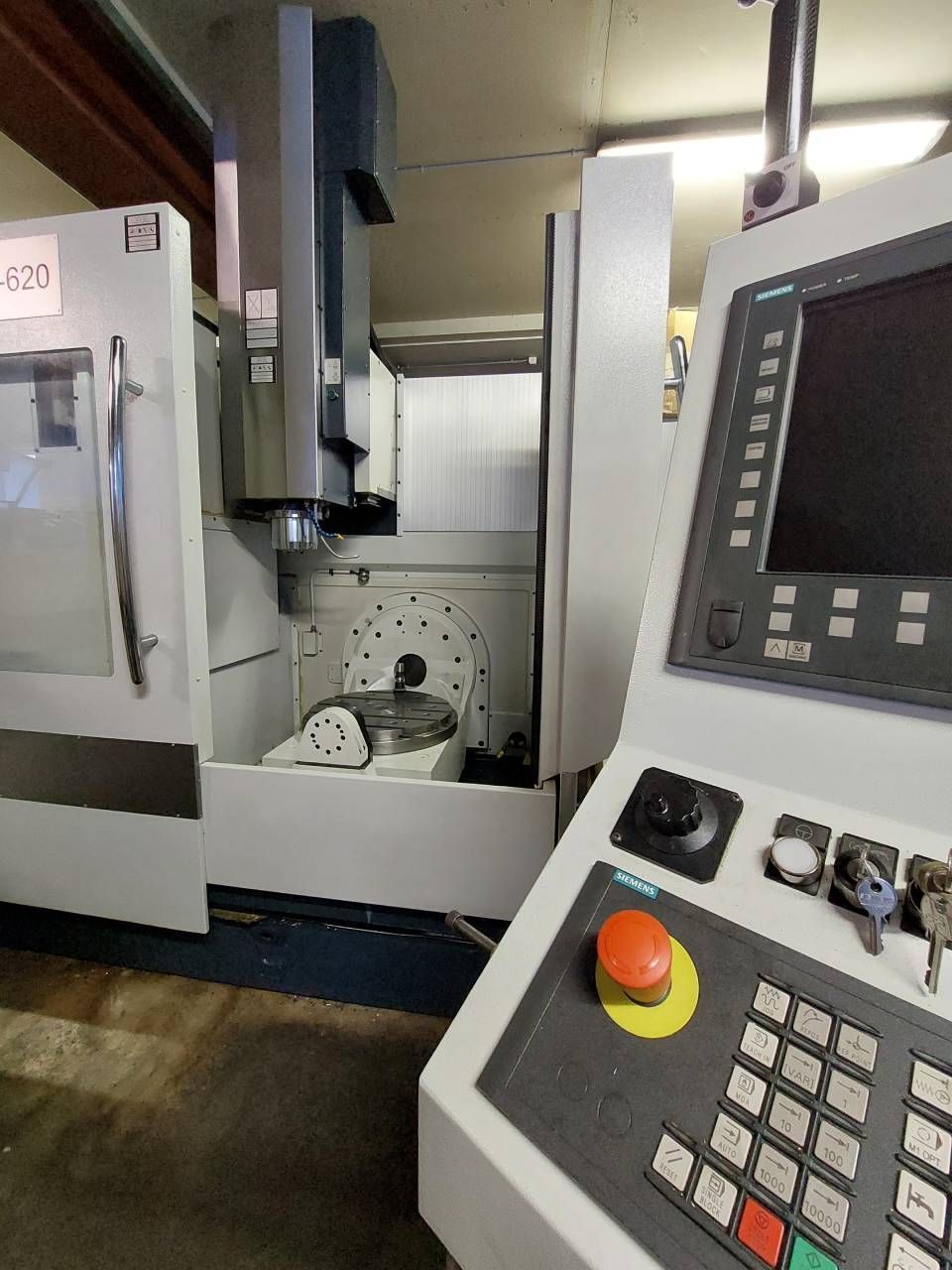 CNC-Fräsmaschine mit Bedienfeld und Betriebskomponenten. Grau und weiss.