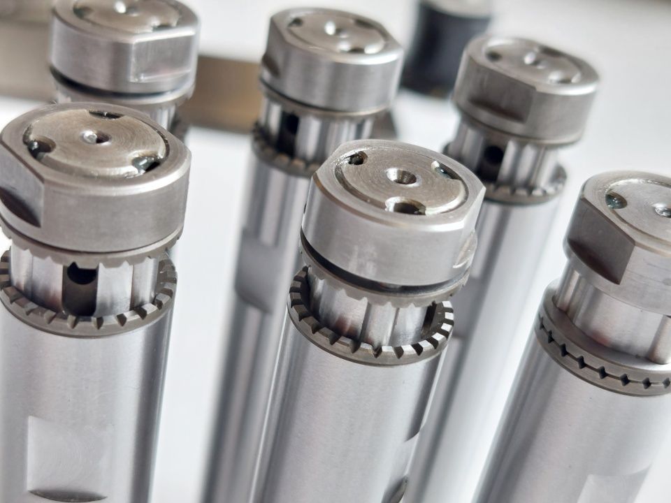 Ein Haufen kleiner, messingfarbener Metallarmaturen, möglicherweise für Sanitär- oder Industriezwecke.