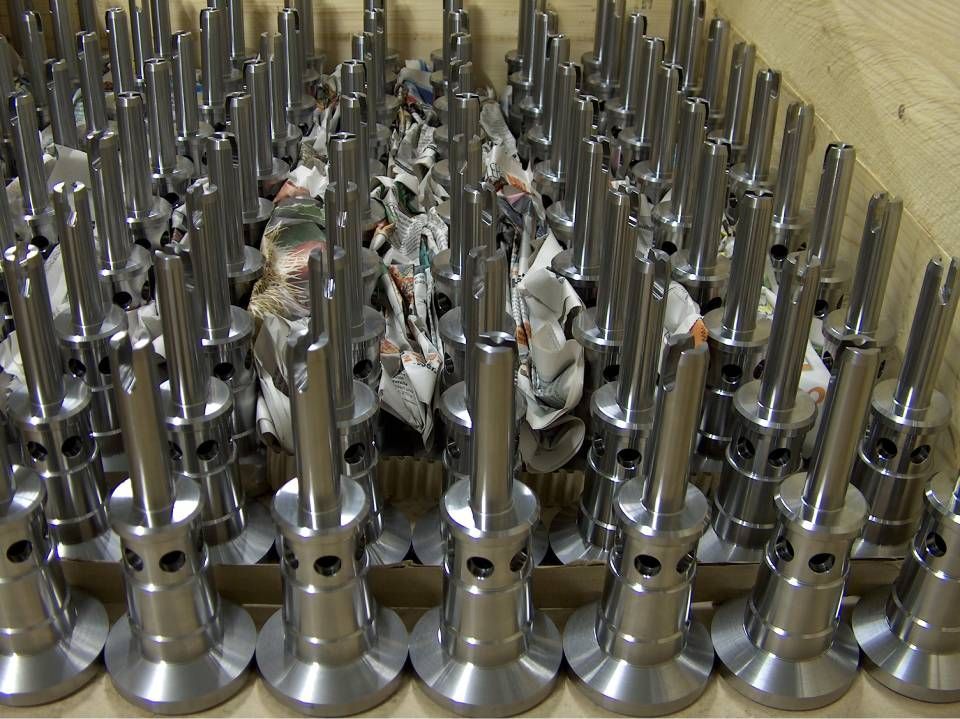 Eine Kiste voller glänzender, metallener Industrieteile.