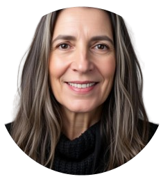 Una mujer con cabello largo y ondulado de color castaño y gris sonríe, vistiendo un suéter negro, sobre un fondo gris.